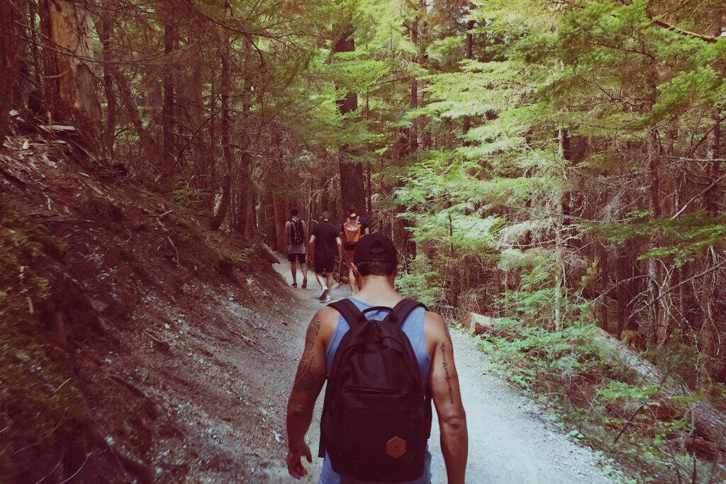 Man wears a backpack while hiking on a trail