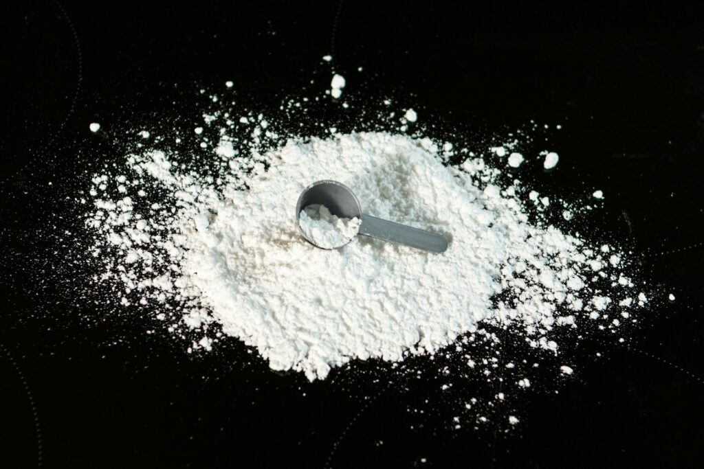 A pile of creatine with a scooper in the middle