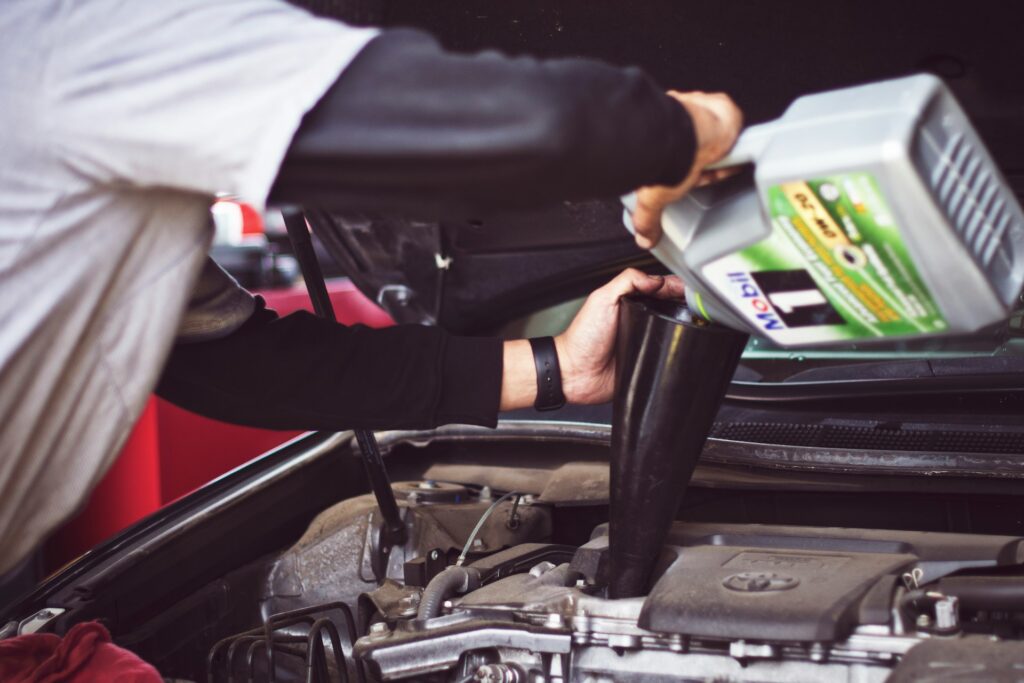 man topping off motor oil