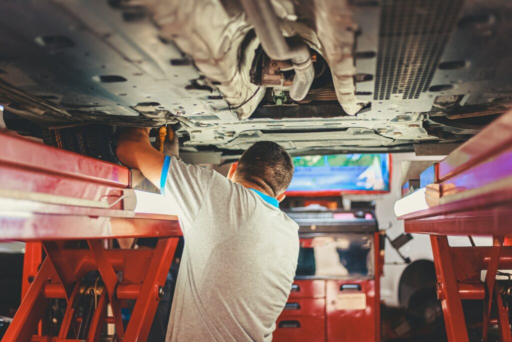 mechanic working on the underside of a car