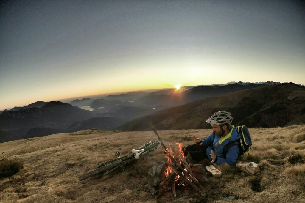 A lone wolf taking a breather from biking by staying warm by a bonfire.