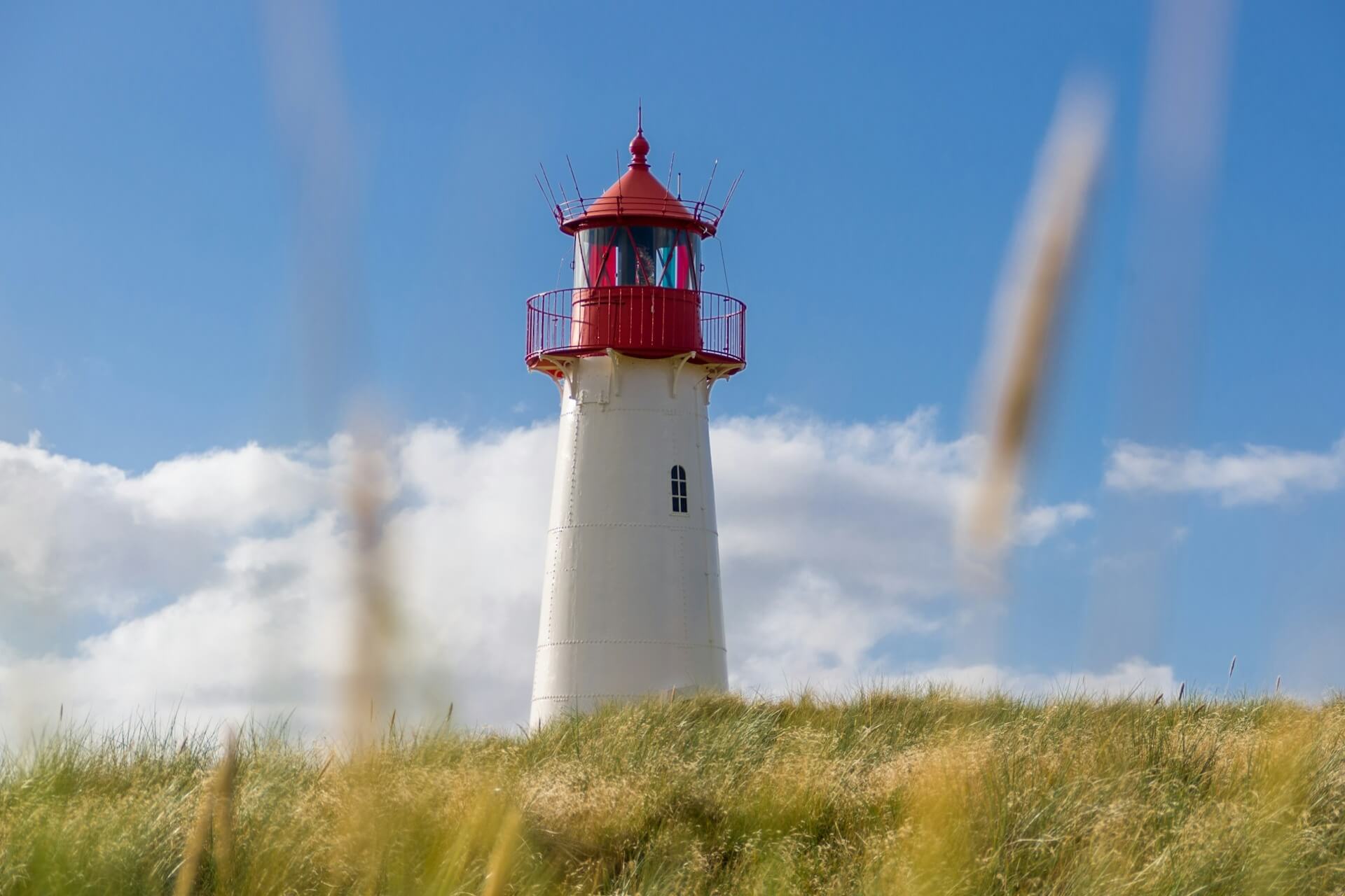 Lighthouse on a grassy hill in the afternoon