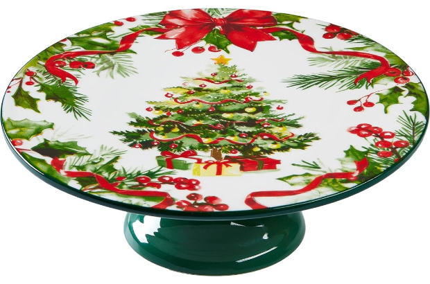 a wide-rimmed round cake stand decorated with images of garlands and a Christmas tree