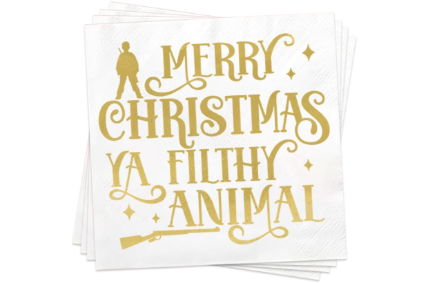 a stack of napkins saying "Merry Christmas Ya Filthy Animal" in gold font